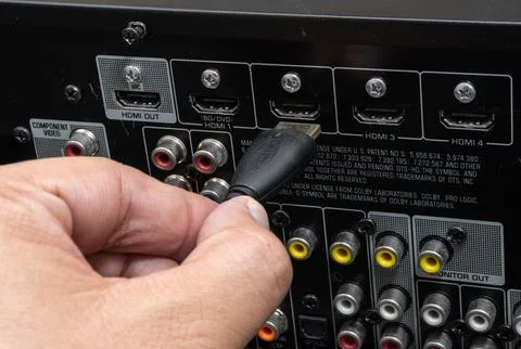 Close-up of hand connecting HDMI cable to home theater device Stock Photos