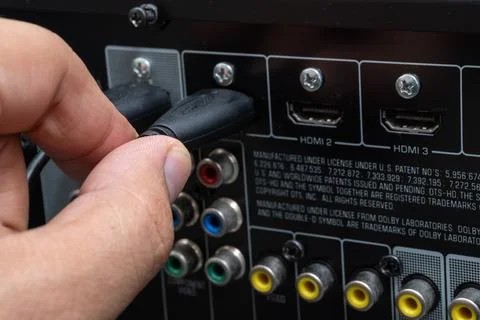 Close-up of hand connecting HDMI cable to home theater device Stock Photos