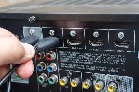 Close-up of hand connecting HDMI cable to home theater device Stock Photos