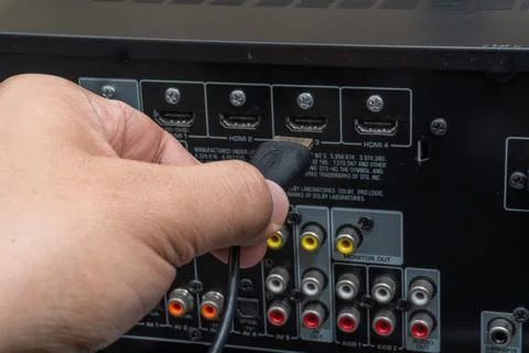 Close-up of hand connecting HDMI cable to home theater device Stock Photos