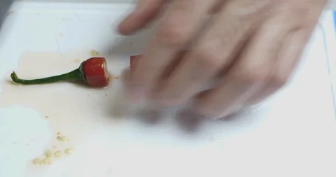 Close-up Hand Of A Cook Cuts Fresh Hot Red Chili Peppers With A Knife Stock Footage 128096336