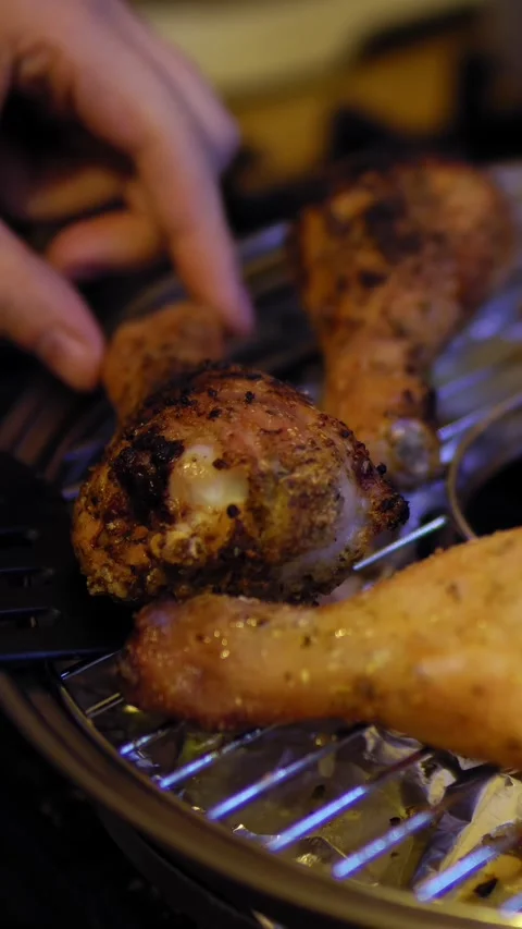 Close-up of hand with cooking spatula flips pieces of poultry for even roasting. Stock Footage 265604552
