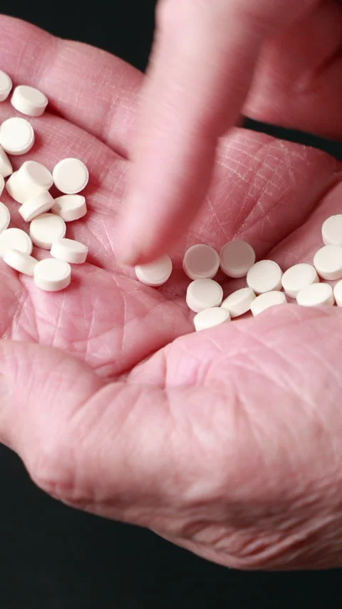 Close-Up Of A Hand Counting Small White Pills On The Palm, Highlighting Medicati Stock Footage 319206370