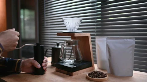 Close up hand crank coffee grinder by spilling hot water through a layer of grou Stock Footage 160199055