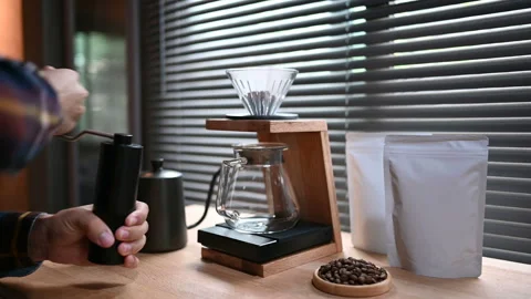 Close up hand crank coffee grinder by spilling hot water through a layer of grou Stock Footage 163651825