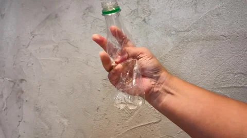 Close Up of Hand Crushing Plastic Water Bottle for Recycling Stock Footage 343836578