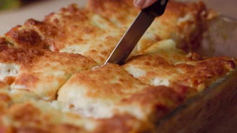 Close up of a hand cutting delicious lasagna in slowmotion Stock Footage 301733872