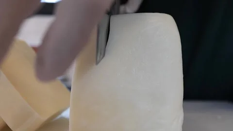 Close-up of hand cutting fresh dough with a knife on a wooden board Stock Footage 331955701