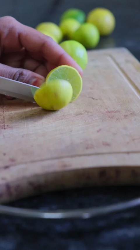 Close-up of hand cutting fresh lemon on wooden board 스톡 동영상 332228073
