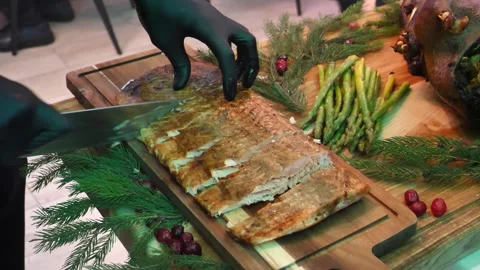 Close-up of hand cutting grilled salmon steak with vegetables. Christmas table Stock Footage 260241309