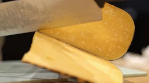 Close-up of hand cutting large pieces of French cheese.Cutting Cheese Slices Stock Footage 280108510