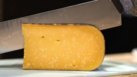 Close-up of hand cutting large pieces of French cheese.Cutting Cheese Slices Stock Footage 280108520