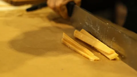 Close-up of hand cutting large pieces of French cheese.Cutting Cheese Slices Stock Footage 287185443