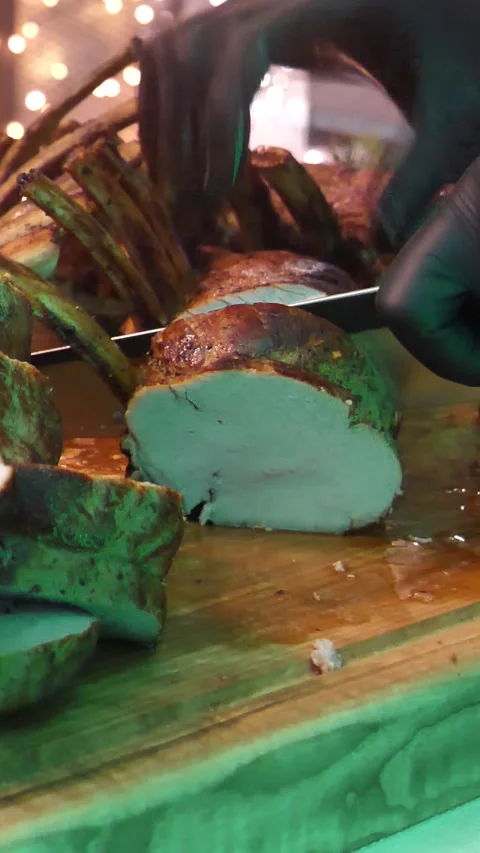 Close-up of hand cutting a rack of lamb on the grill. Christmas table Stock Footage 304657071