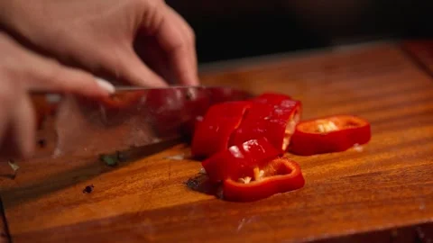 Close Up of Hand Cutting Red Pepper on Wooden Cutting Board Stock Footage 336466934