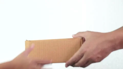 Close up hand of Delivery man delivering holding parcel box to customer on white Stock Footage 136900568