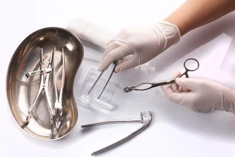 Close up hand dentist is selecting a tool used to treat patient teeth. Stock Photos