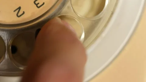 Close-Up of a Hand Dialing a Phone Number on a Vintage Rotary Telephone 動画素材 339725517