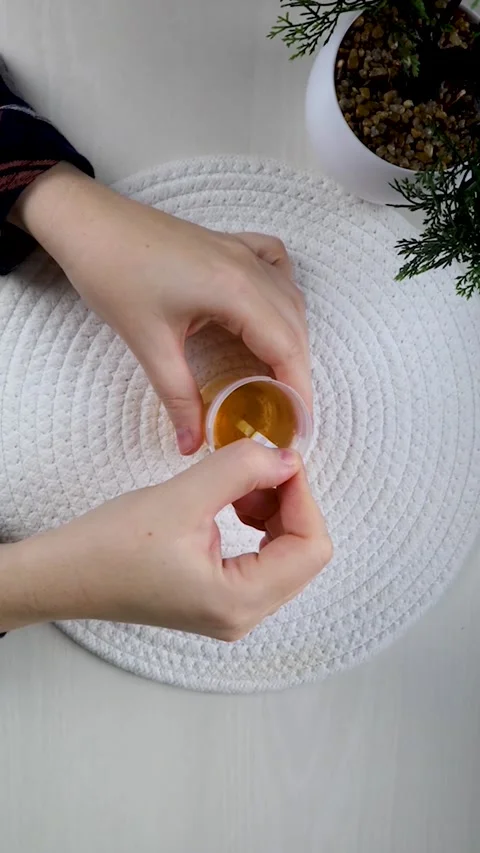 A close-up of a hand dipping a urine test strip into a container for medical dia Stock-Footage 344944613