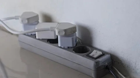 Close-up of hand disconnecting multiple plugs from power strip to reduce Stock Footage 332035218