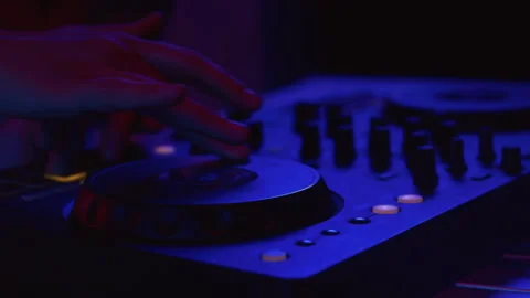 Close up: hand of DJ uses a mixer to mix the music. The artists fingers bring Stock Footage 319762276