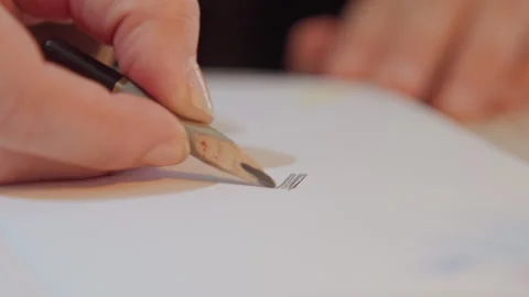 Close up of hand drawing parallel lines with ink pen on white paper showing Stock Footage 345066449