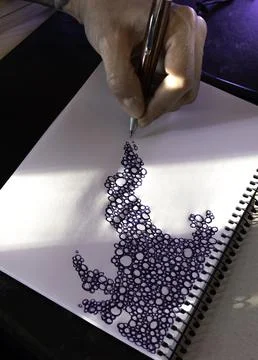Close up of a hand drawing a pattern of scribbled bubbles Stock Photos