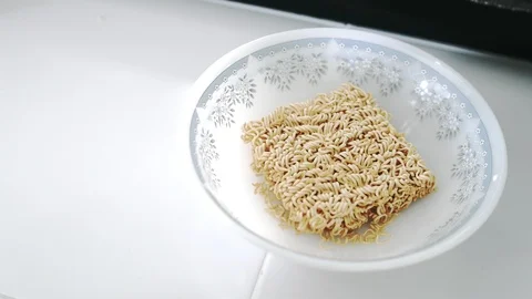 Close up of Hand dumping MAMA instant noodle seasoning powder onto the noodle. Stock-Footage 107914046