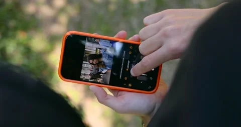Close-up of hand editing portrait photo in Luminar app on iPhone outdoors Stock Footage 336774792