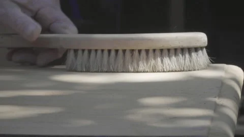 Close up of the hand of an elderly craftsman sanding and cleaning sawdust Stock Footage 140293603