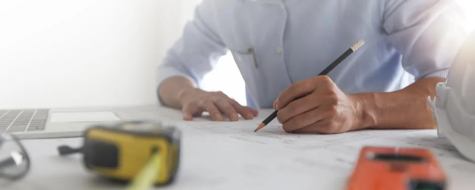 Close up hand of engineer draw and draft on blueprint on table, architect w.. Stock Photos