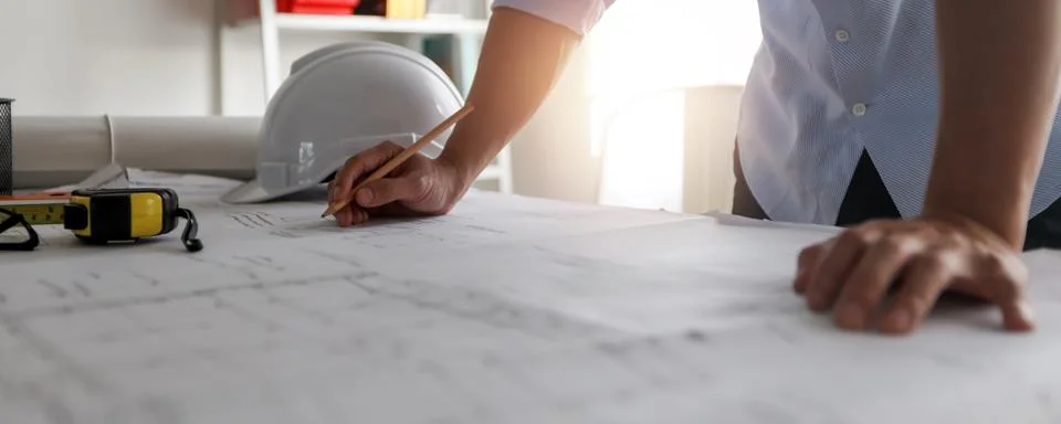 Close up hand of engineer draw and draft on blueprint on table, architect w.. Stock Photos