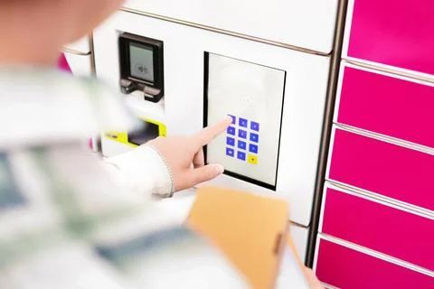 Close up of a hand entering a pin code on a parcel locker touchscreen termi.. Stock-Fotos