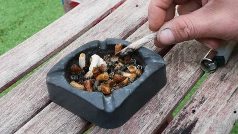 Close up hand extinguishing cigarette in dirty old ashtray Stock Footage 328522290