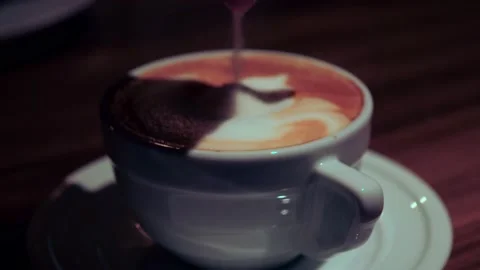 Close up hand falling sugar into coffee cup. top view of coffee. Cappuccino with Stock Footage 228826352