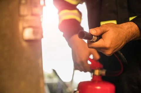 Close up hand Fireman using fire extinguisher fighting. Stock Photos