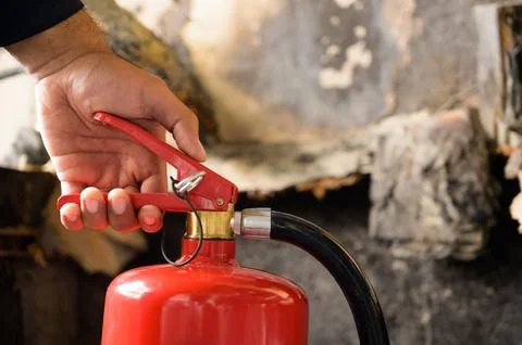 Close up hand Fireman using fire extinguisher fighting. Stock Photos
