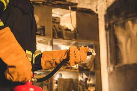 Close up hand Fireman using fire extinguisher fighting. Stock Photos