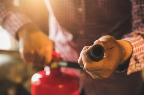 Close up hand Fireman using fire extinguisher fighting. Stock Photos