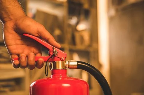 Close up hand Fireman using fire extinguisher fighting. Stock Photos