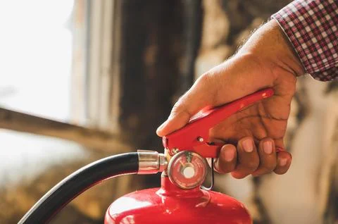 Close up hand Fireman using fire extinguisher fighting. Stock Photos