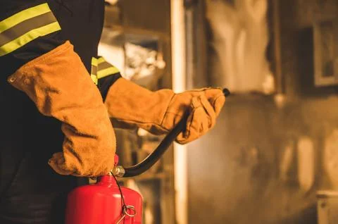 Close up hand Fireman using fire extinguisher fighting. Stock Photos