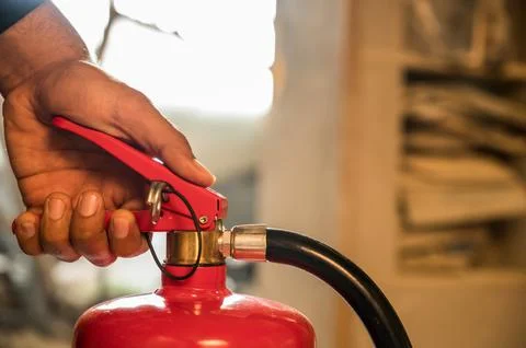 Close up hand Fireman using fire extinguisher fighting. Stock Photos