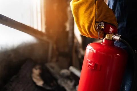 Close up hand Fireman,Firefighter holding the fire extinguisher. Stock Photos