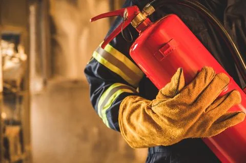 Close up hand Fireman,Firefighter holding the fire extinguisher. Stock Photos