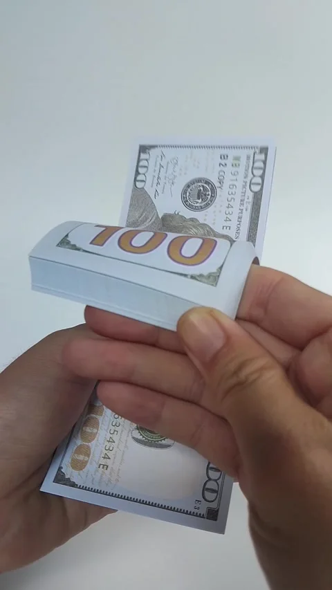 Close-up of a hand flipping through a stack of U.S. one hundred dollar bills Stock Footage 324848323