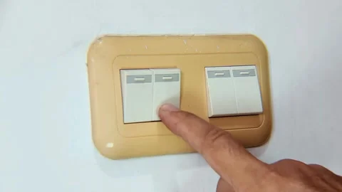 Close-up of hand flipping wall light switch to turn off light Stock Footage 338448036