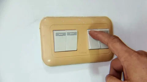 Close-up of a hand flipping a wall light switch to turn the light on and off. Stock Footage 338448195