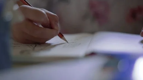 Close up of hand in focus drawing something on white paper sheet. Creativity Stock Footage 80636714