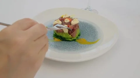 Close up of a hand with a fork eating a tartar with a raw tuna fish. Video stock 197748411